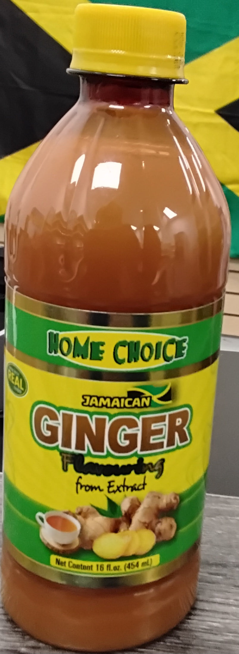 A 16 fl oz bottle of TOJ EXPRESS Home Choice Jamaican Ginger Extract, with a yellow cap, green label showing ginger and tea, and a Jamaican flag in the background.