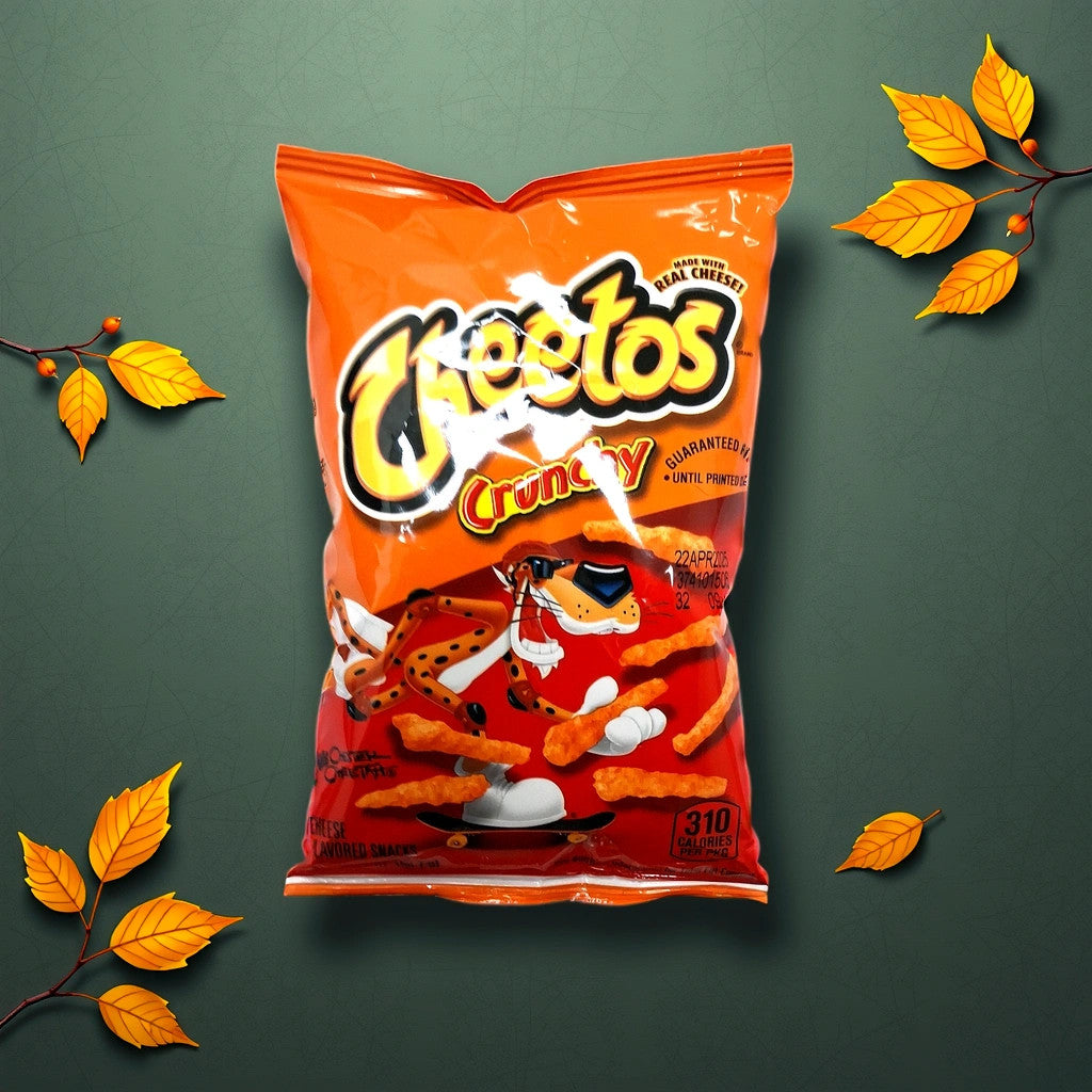 A bag of TOJ EXPRESS Cheetos, in its iconic orange packaging, rests on a green surface, surrounded by autumn leaves. Its the perfect snack to satisfy those cravings with a seasonal touch.