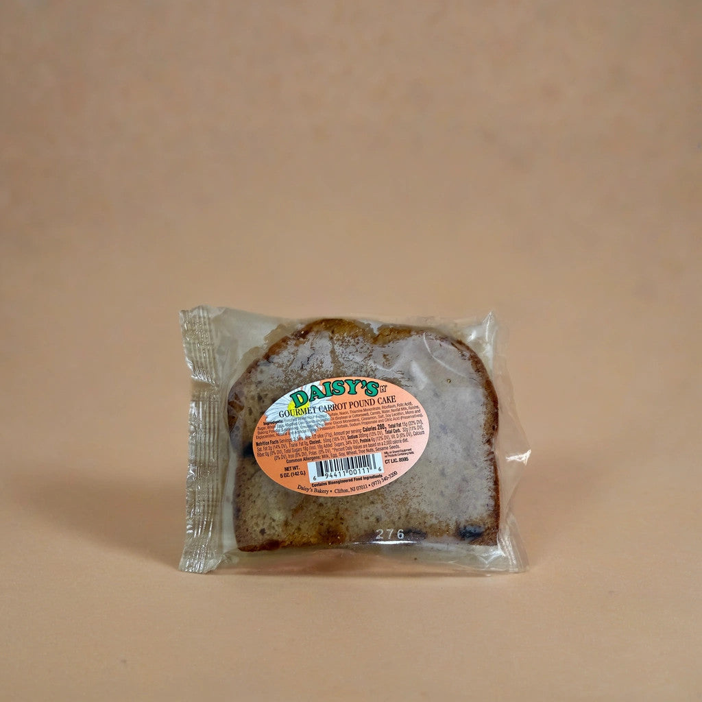A packaged slice of TOJ EXPRESS Daisy's Gourmet Carrot Pound Cake rests on a beige background, its tempting treat visible through a clear wrapper and an inviting orange label displayed on the front.