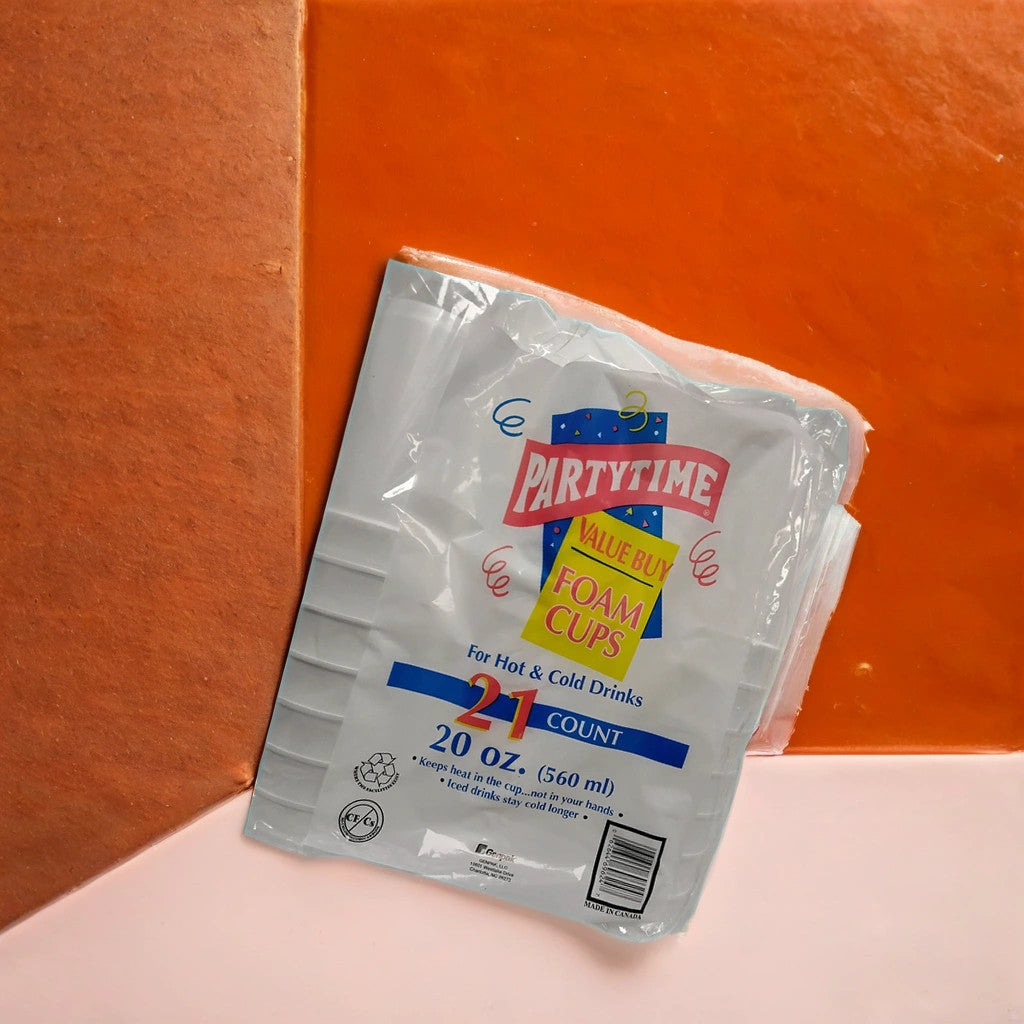 A pack of TOJ EXPRESS Partytime Foam Cups (20 oz, 21 ct) sits on an orange, peach, and pink background—durable and versatile cups for hot or cold drinks, perfect for any party occasion.