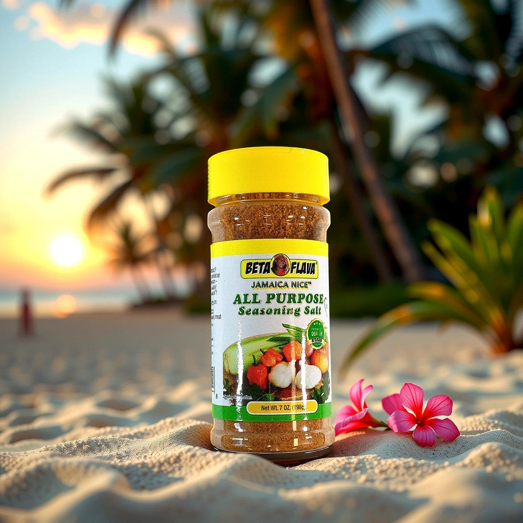 A jar of TOJ EXPRESS BETA FLAVA All Purpose Seasoning rests on a sandy beach during sunset, with palm trees and the ocean as a serene backdrop. Pink flowers adorn the foreground, and this versatile seasoning captures the essence of paradise, perfectly flavoring any dish.