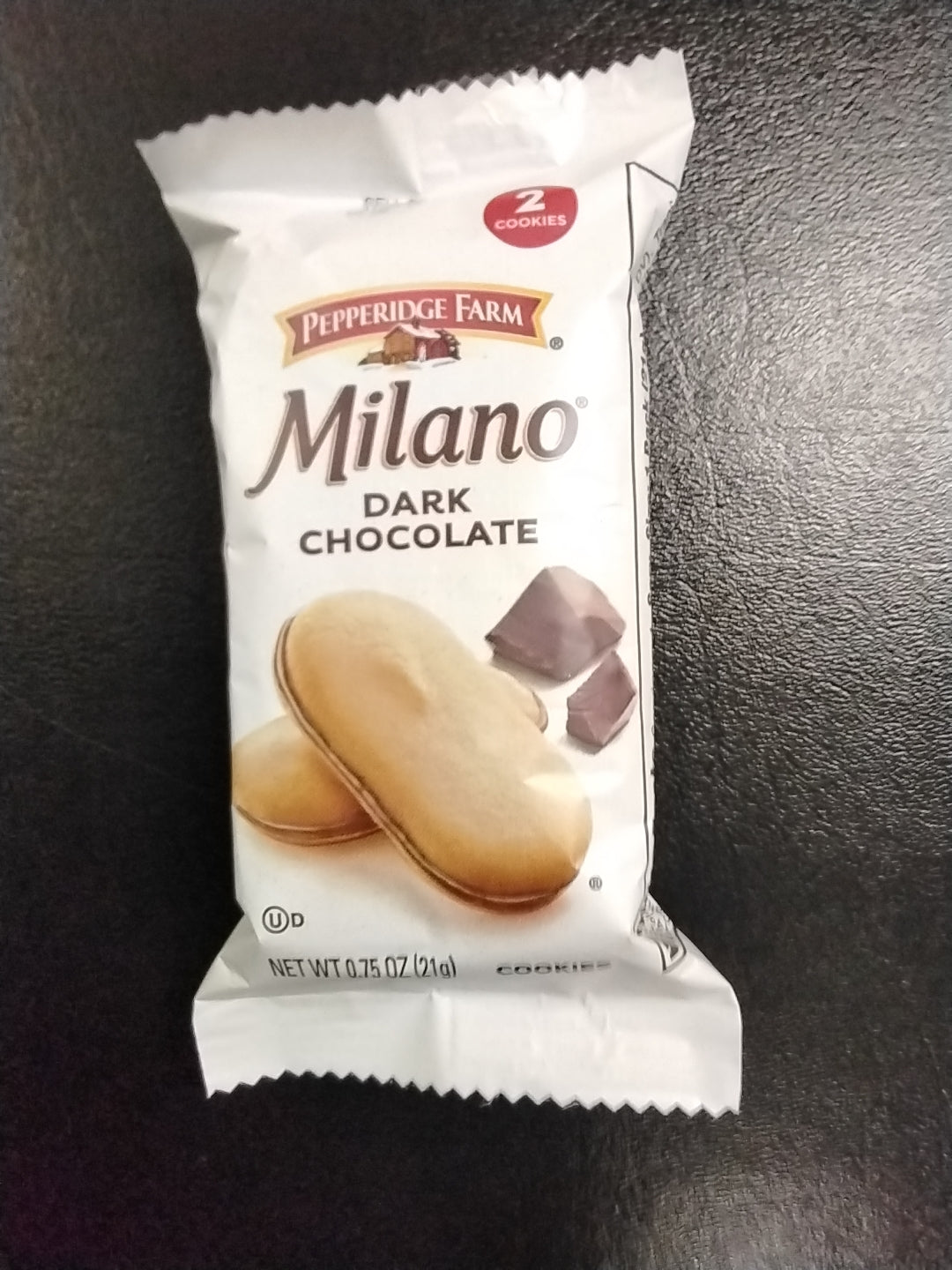 A white package of TOJ EXPRESS Milano Dark Chocolate Crackers features two crackers and pieces of dark chocolate on the front, all set against a dark surface.