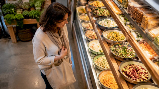 Woman selecting refrigerated deli salads in store