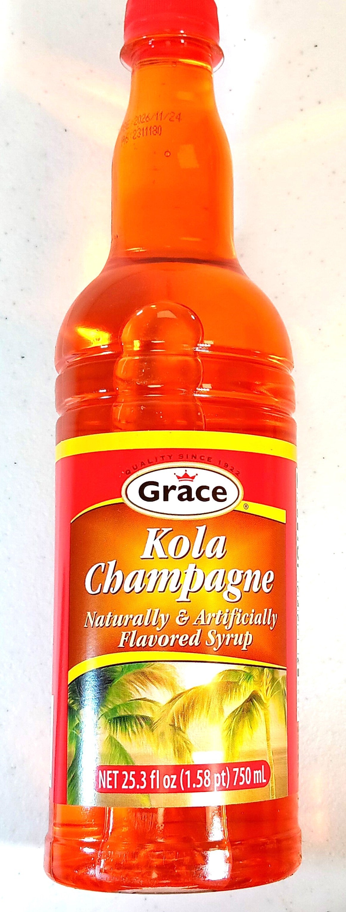 A bottle of Grace Kola Champagne syrup with an orange label and cap. The label reads Naturally & Artificially Flavored Syrup, with images of tropical scenery. Volume is 750 mL (25.3 fl oz).