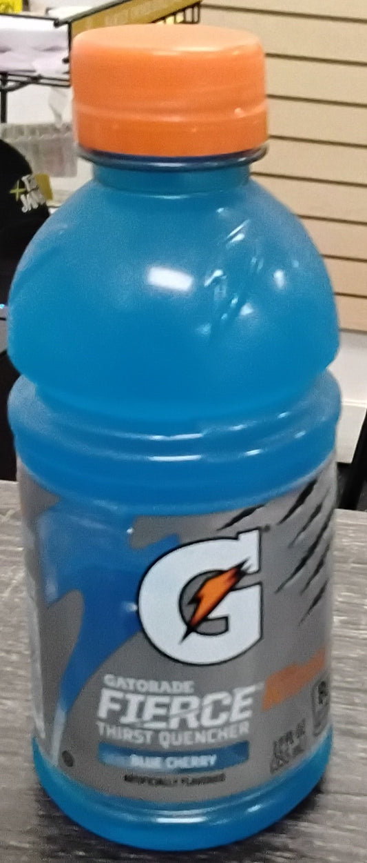 A 12 oz bottle of TOJ EXPRESS Gatorade Blue Cherry sits on a wooden surface, featuring a blue drink, orange cap, and label with the Gatorade lightning bolt logo.