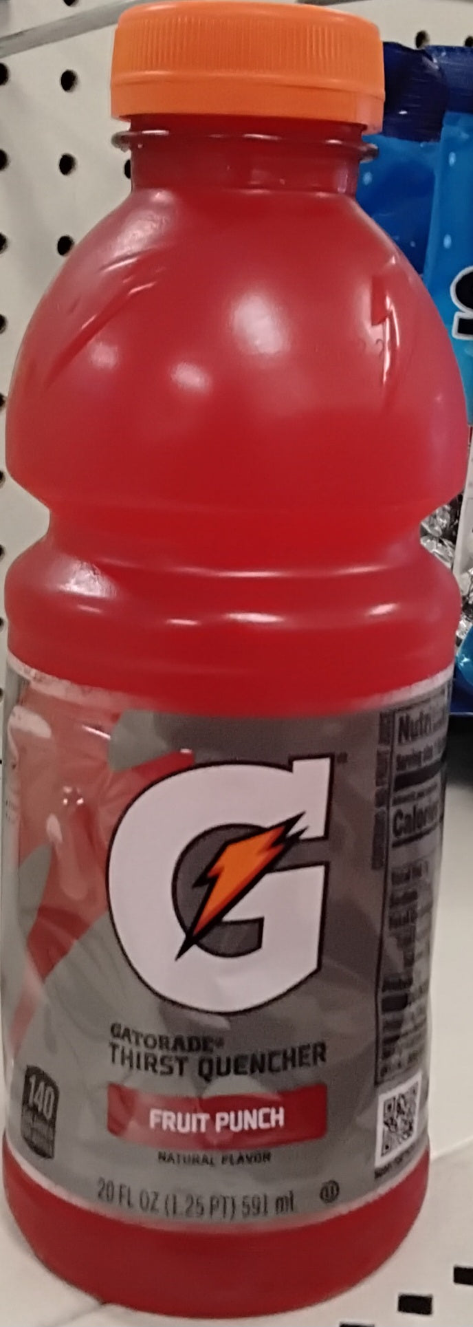 A 20 fl oz bottle of TOJ EXPRESS Gatorade Fruit Punch Drink with a red liquid, an orange cap, and a large G logo on the label sits on a store shelf.