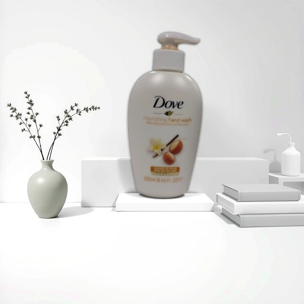 A bottle of TOJ EXPRESS Dove Handwash Soap (8.5 oz) sits on a white platform, with stacked books, a white vase with branches, and another dispenser nearby, creating a serene setting that emphasizes this gentle, hydrating hand soap.