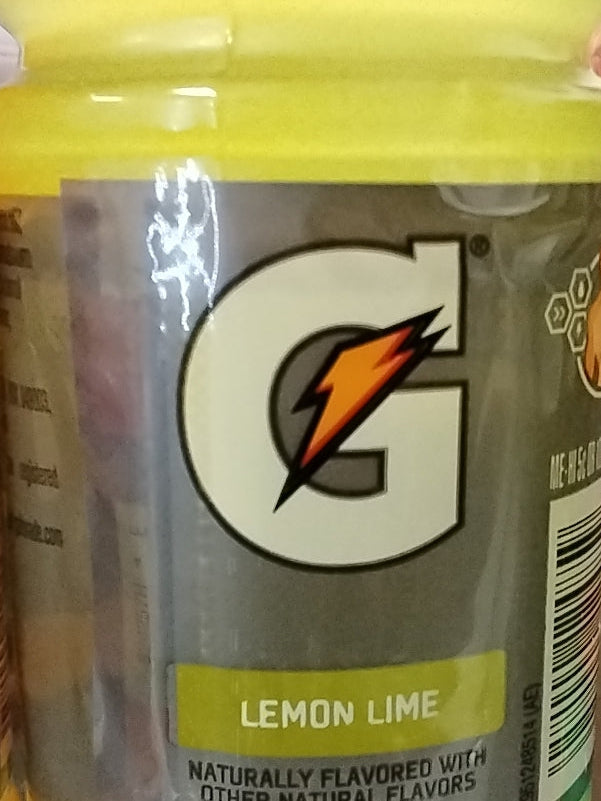 Close-up of a TOJ EXPRESS Gatorade Lemon Lime Drink (12 oz) label, featuring the prominent G logo with an orange lightning bolt and "Lemon Lime" in a green box, emphasizing hydration and balanced electrolytes.